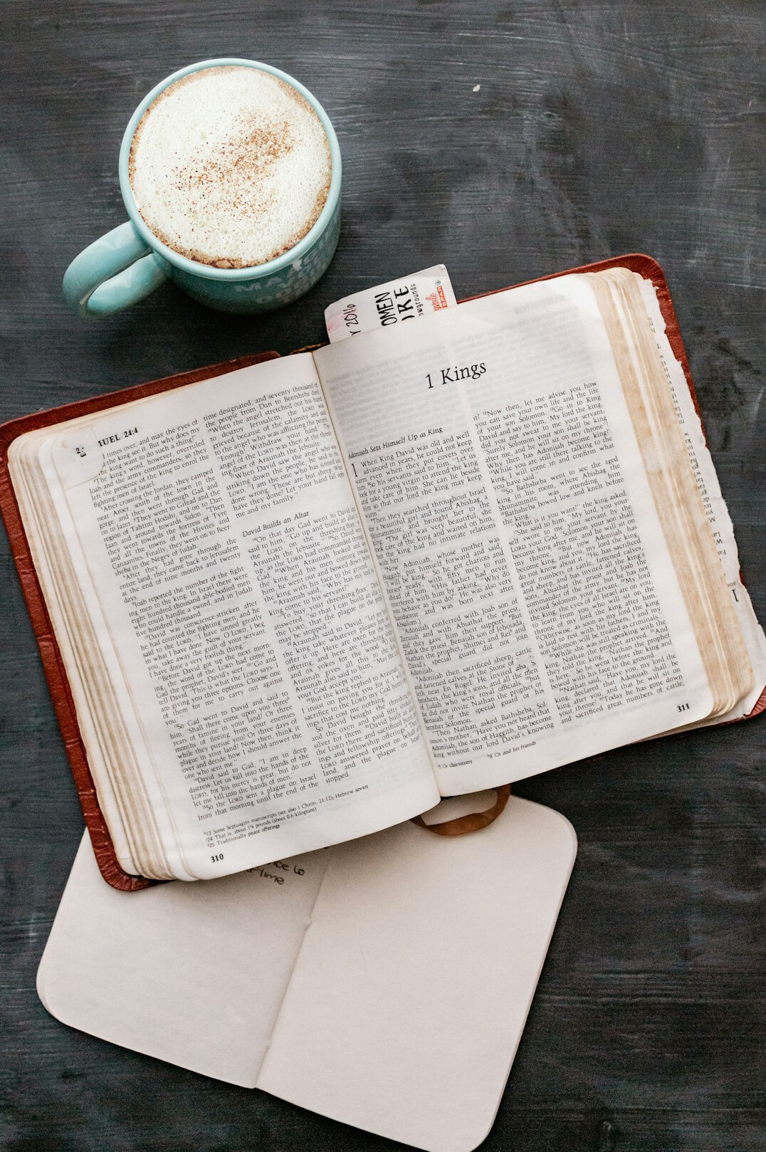 Open notebook with handwritten notes and a cup of coffee
